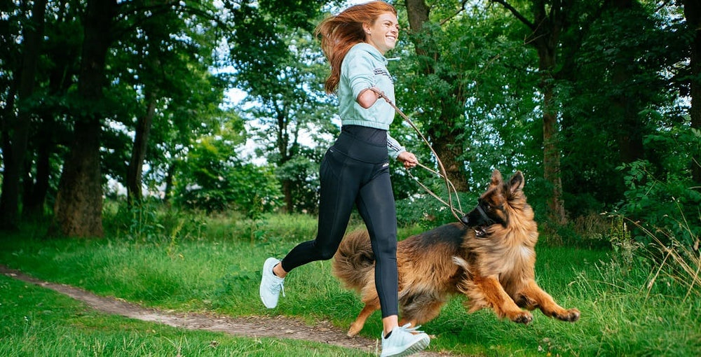 Lady running with her GSD+