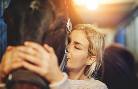 Young woman holding horse