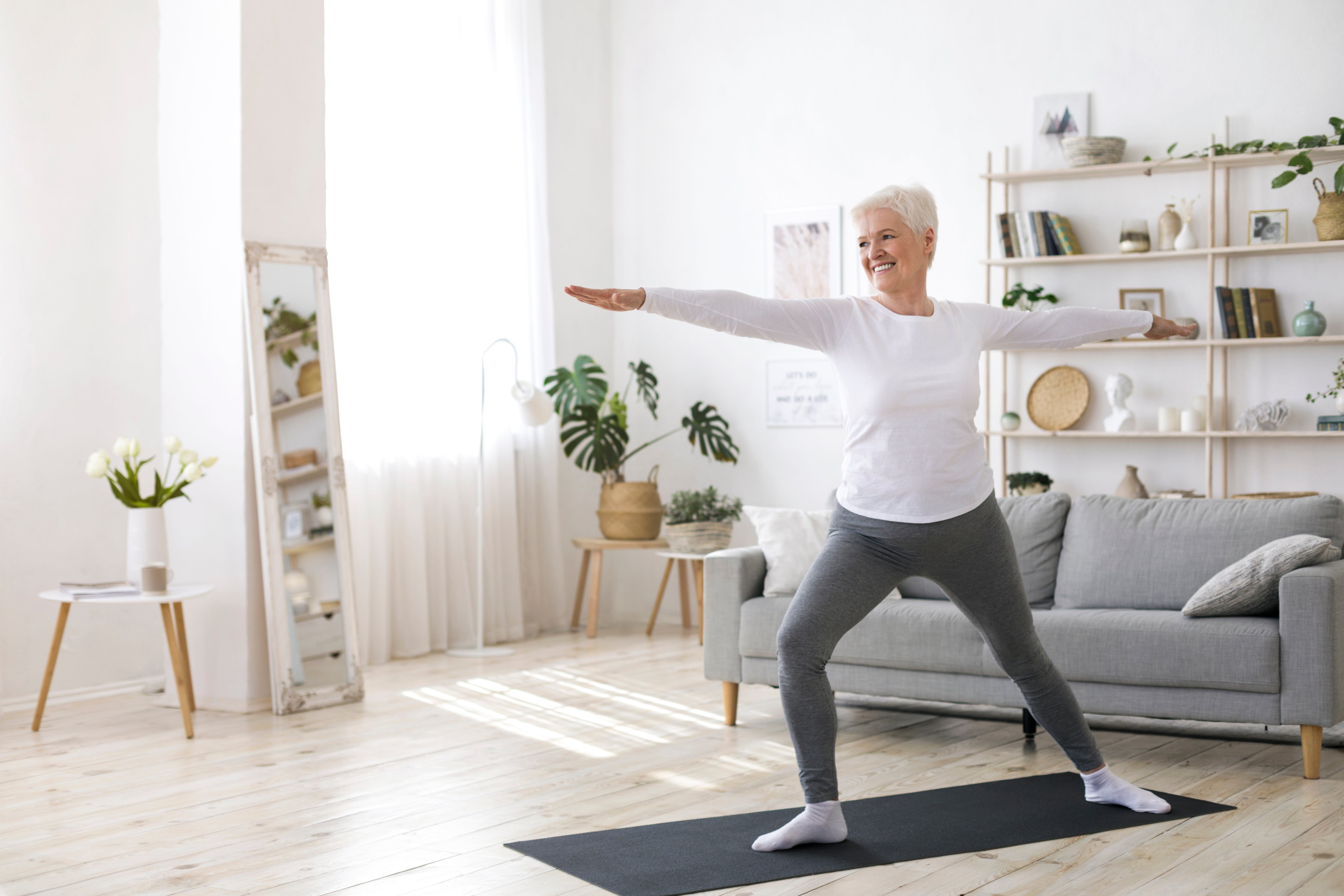 Elderly woman exercising stretching at home