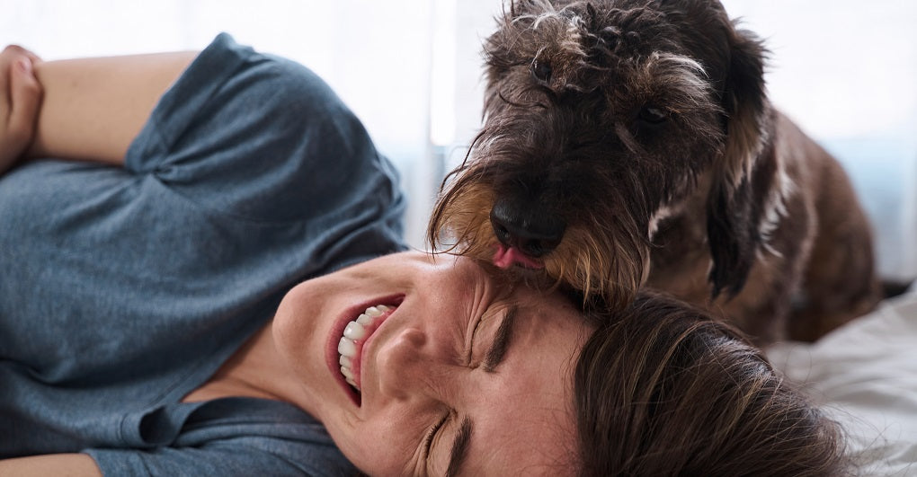 Lady getting her face licked by her dog