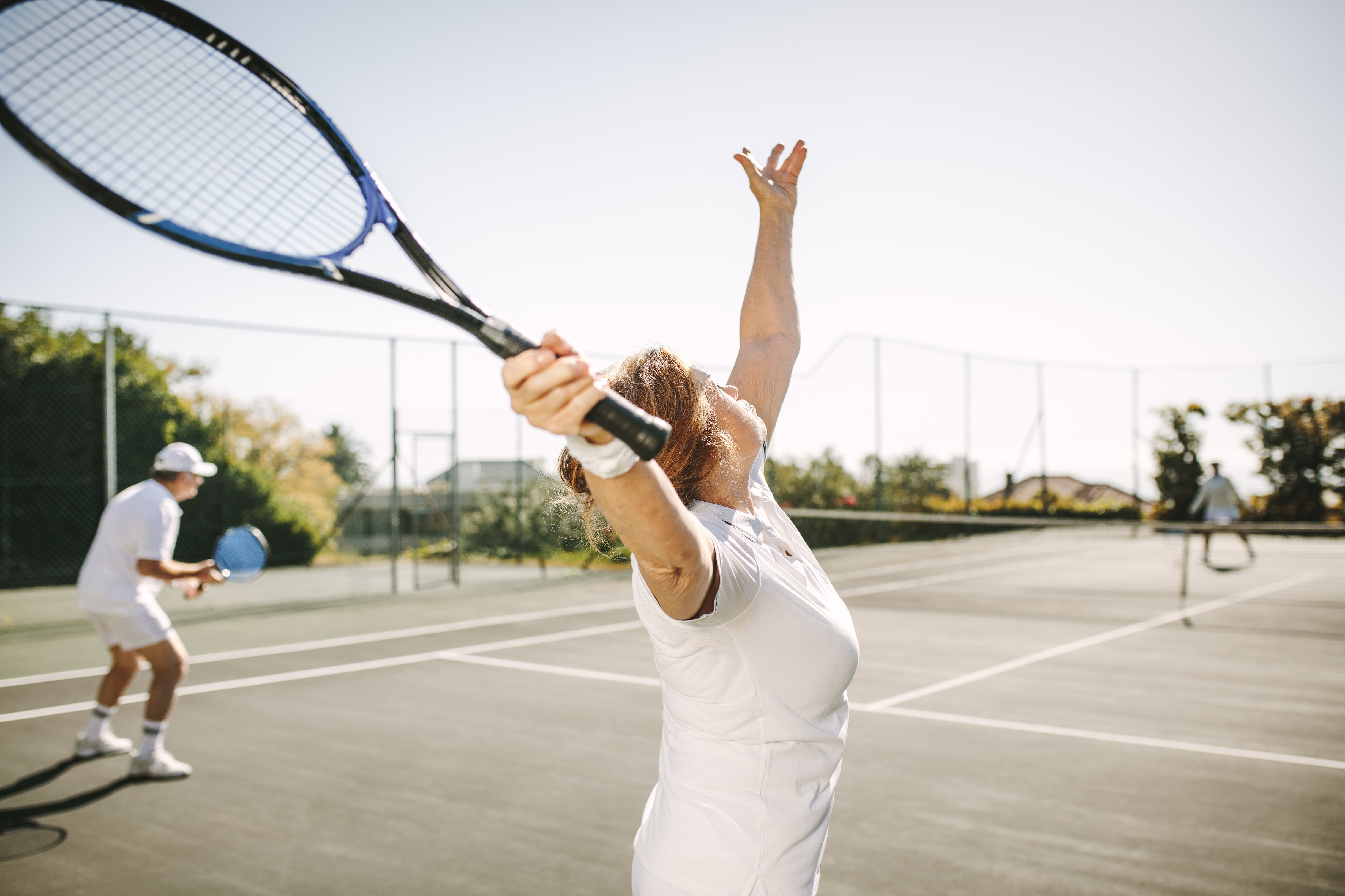 older woman playing tennis